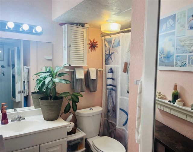 bathroom with toilet, vanity, and a shower with curtain