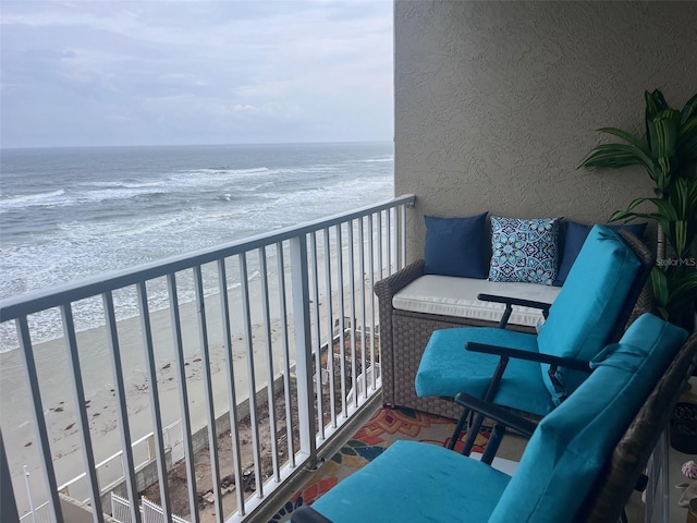 balcony featuring a beach view and a water view
