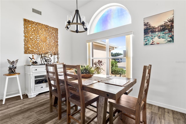 dining space with a notable chandelier, dark hardwood / wood-style floors, and a high ceiling