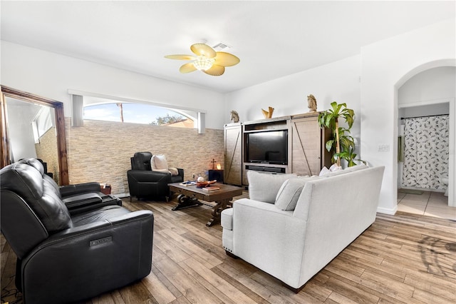 living room featuring light wood-type flooring and ceiling fan