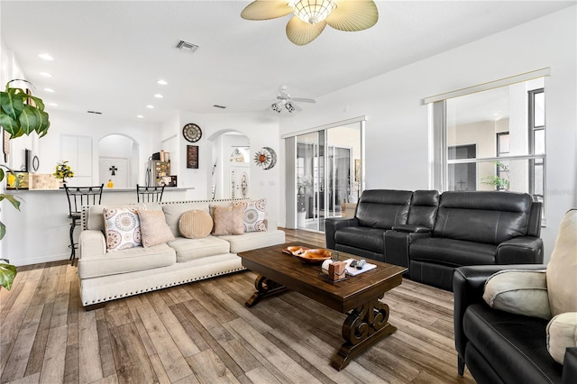 living room with ceiling fan and light hardwood / wood-style flooring