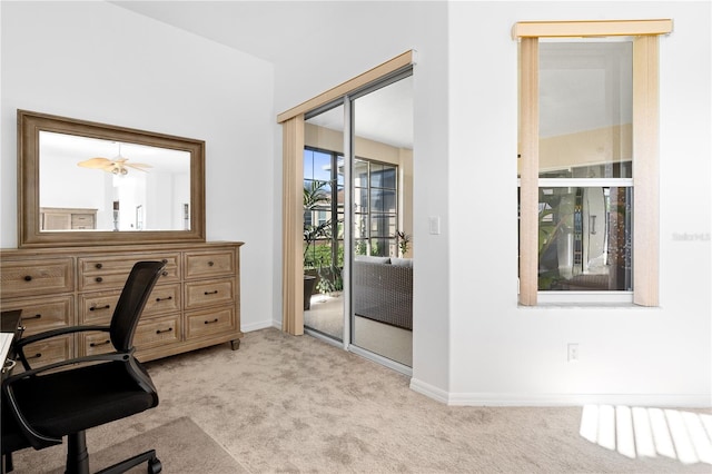 office space featuring light carpet and ceiling fan