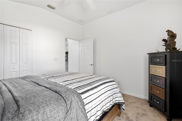 carpeted bedroom featuring a closet, lofted ceiling, and ceiling fan