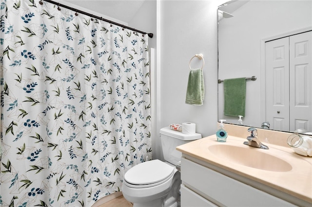 bathroom featuring toilet, curtained shower, and vanity