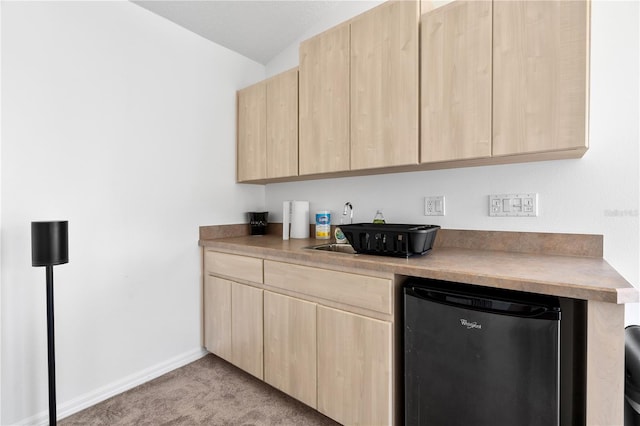 kitchen with light carpet, light brown cabinets, and stainless steel fridge