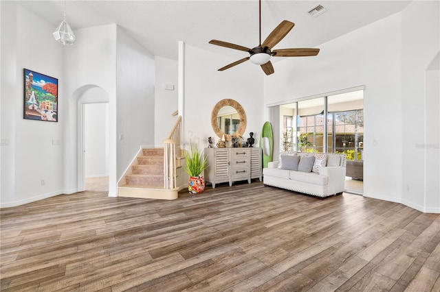 unfurnished living room featuring hardwood / wood-style flooring, high vaulted ceiling, and ceiling fan