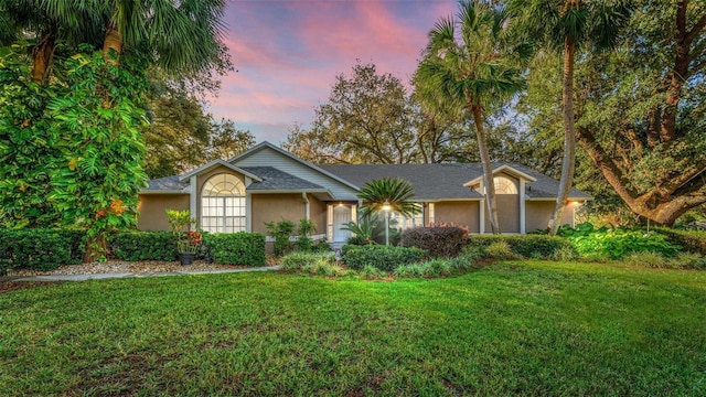 single story home with a lawn