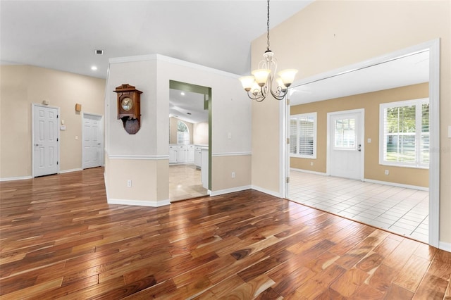 unfurnished dining area featuring hardwood / wood-style flooring and a chandelier