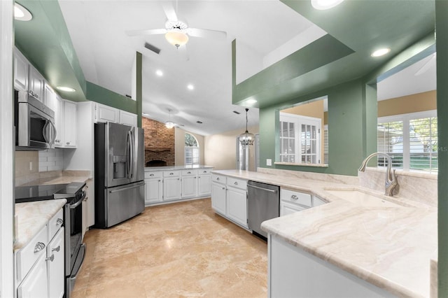 kitchen with kitchen peninsula, white cabinetry, stainless steel appliances, and sink