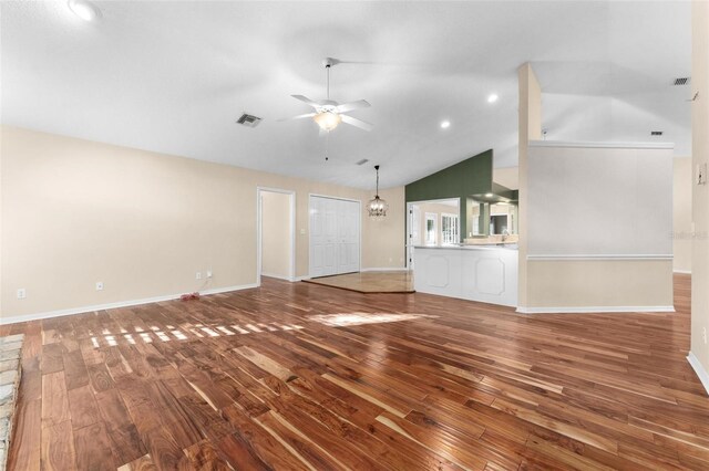 unfurnished living room featuring high vaulted ceiling, hardwood / wood-style flooring, and ceiling fan with notable chandelier