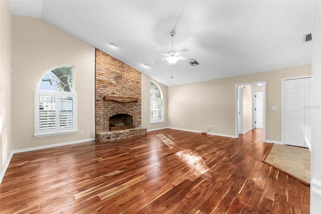 unfurnished living room featuring hardwood / wood-style floors, ceiling fan, a fireplace, and a wealth of natural light