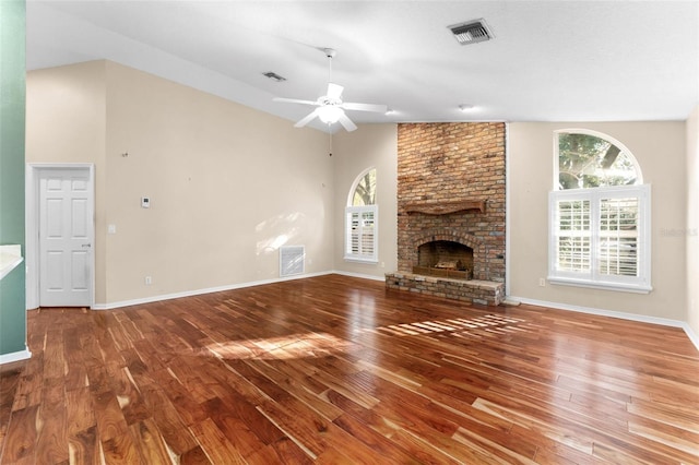 unfurnished living room featuring hardwood / wood-style floors, a brick fireplace, high vaulted ceiling, and ceiling fan