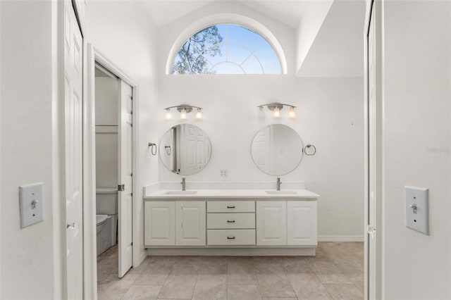 bathroom with vanity, lofted ceiling, toilet, and tile patterned floors