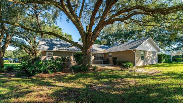 rear view of house with a yard and a patio