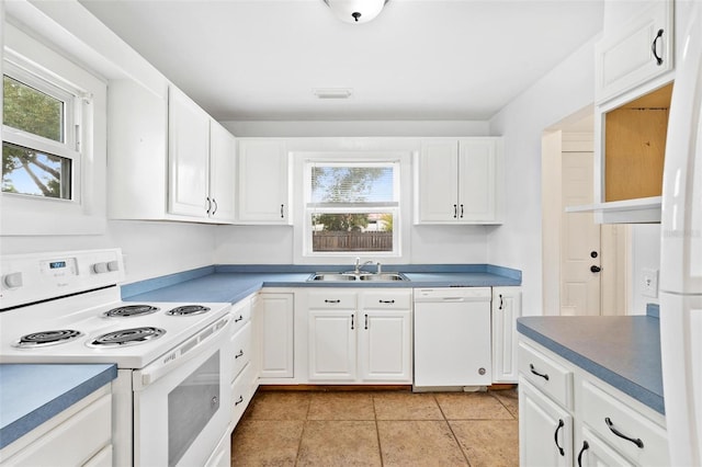 kitchen featuring white appliances, white cabinetry, light tile patterned floors, and sink