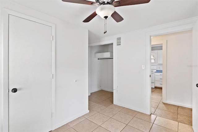 unfurnished bedroom with a closet, light tile patterned floors, and ceiling fan