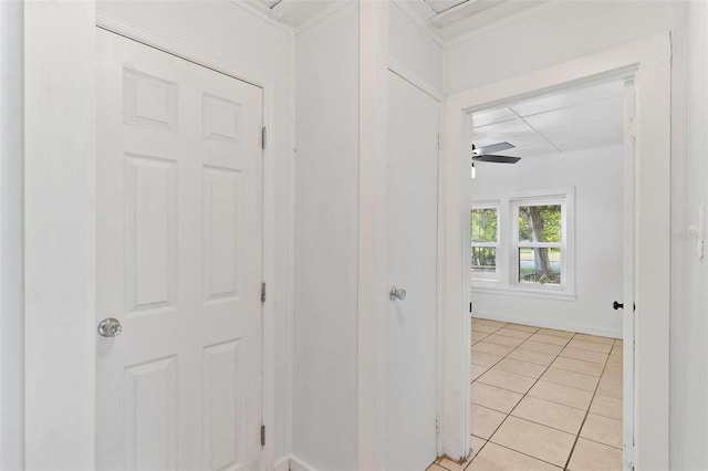 corridor with crown molding and light tile patterned floors