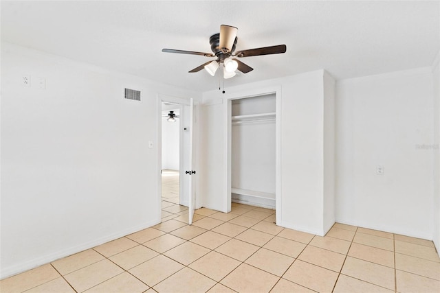 unfurnished bedroom with a closet, ornamental molding, light tile patterned floors, and ceiling fan