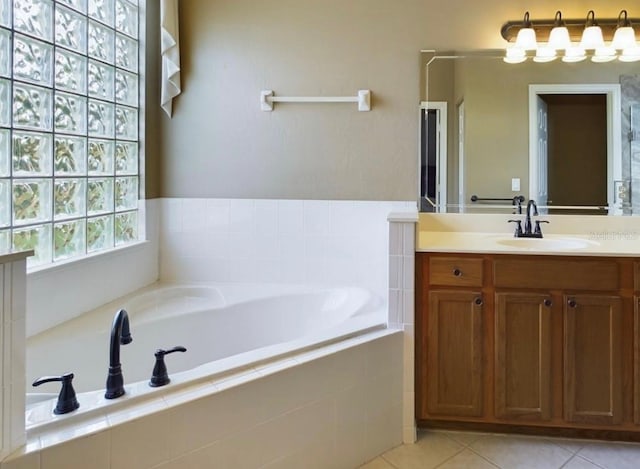 bathroom featuring vanity, a relaxing tiled tub, and tile patterned floors