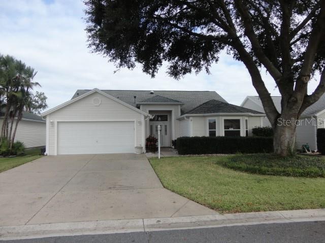 ranch-style home featuring a garage and a front lawn