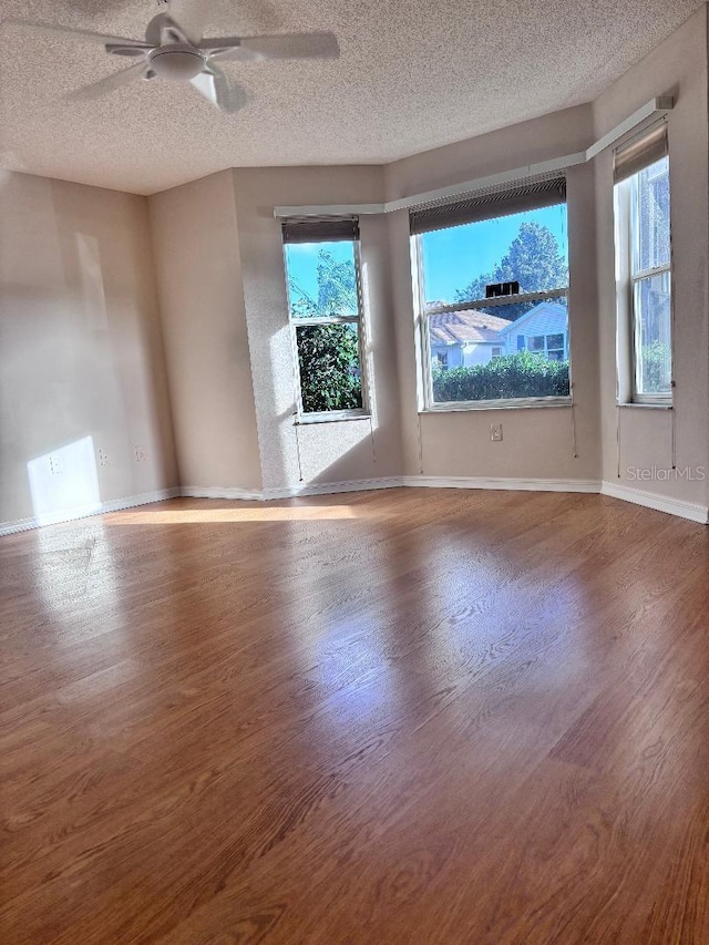 spare room with a textured ceiling, hardwood / wood-style flooring, and ceiling fan