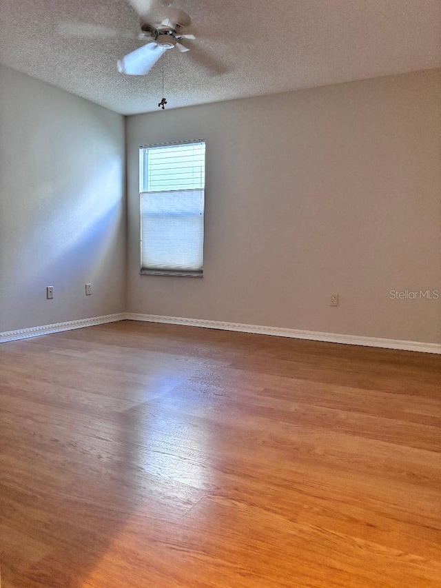 spare room with light hardwood / wood-style floors, a textured ceiling, and ceiling fan