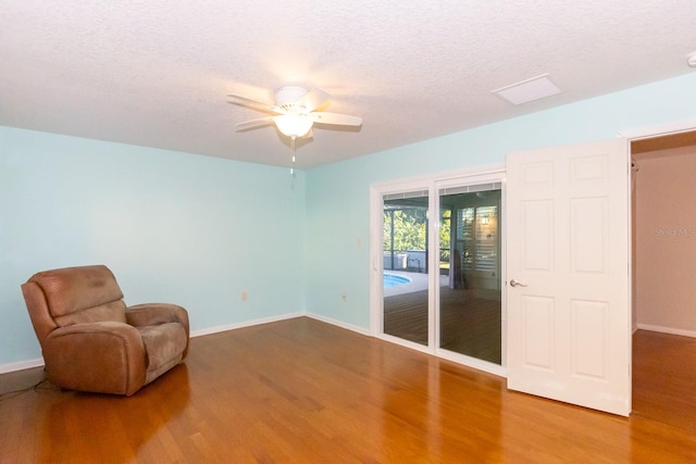 unfurnished room with hardwood / wood-style floors, ceiling fan, and a textured ceiling