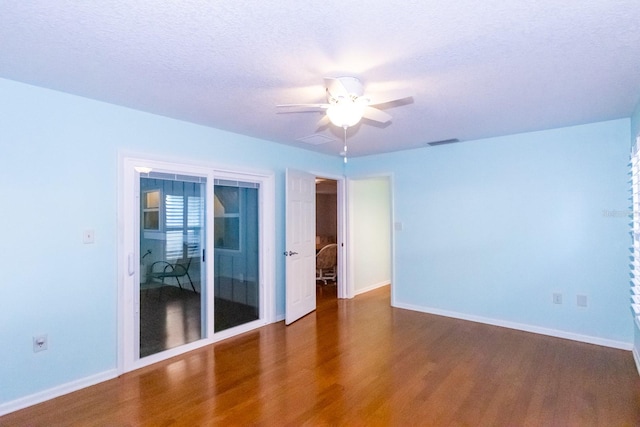 empty room featuring ceiling fan, dark hardwood / wood-style floors, and a textured ceiling