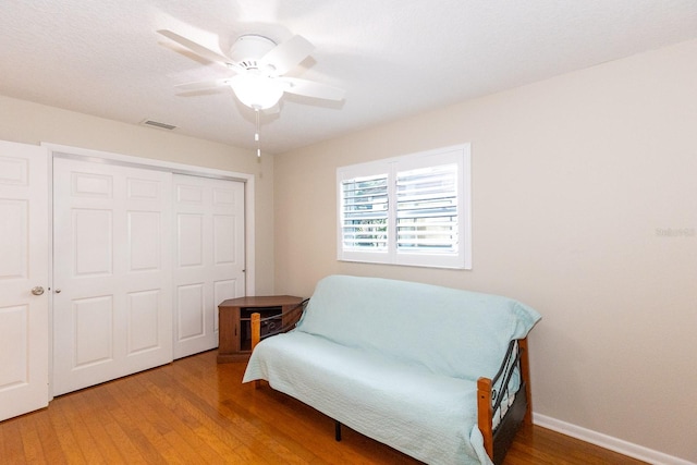 living area featuring wood-type flooring and ceiling fan