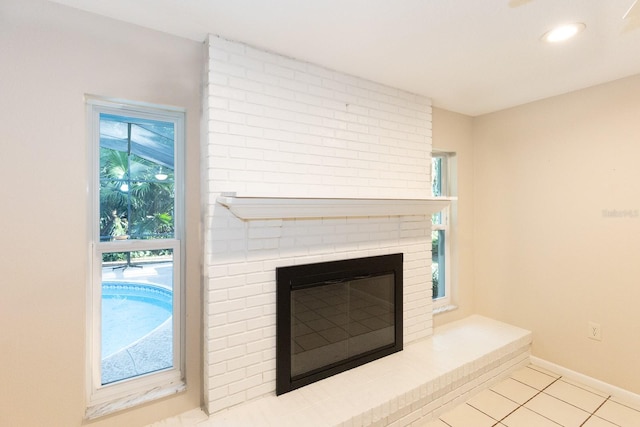 room details with a brick fireplace and tile patterned flooring