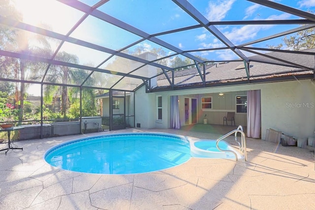 view of pool featuring glass enclosure, a patio area, and ceiling fan