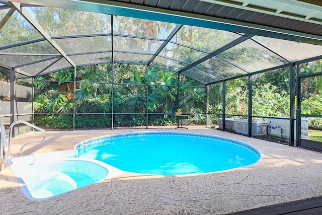 view of pool with glass enclosure and a patio area