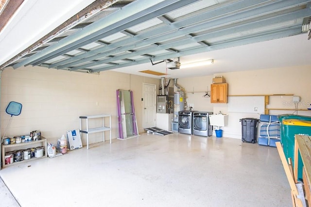 garage with a garage door opener, separate washer and dryer, and sink