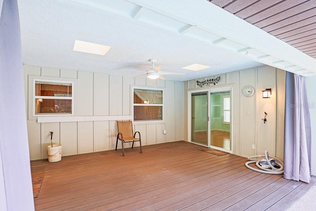 unfurnished sunroom with a skylight and ceiling fan