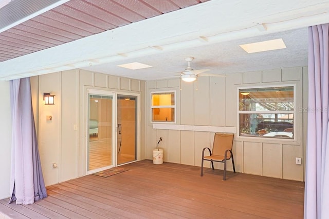 unfurnished sunroom with ceiling fan