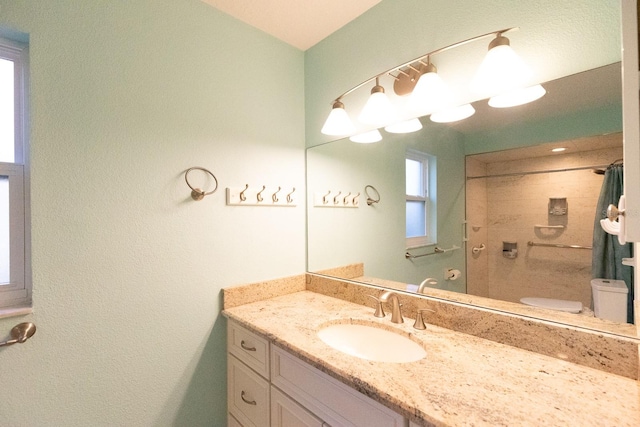 bathroom with toilet, vanity, and curtained shower