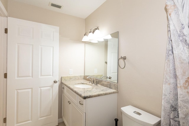 bathroom featuring toilet and vanity