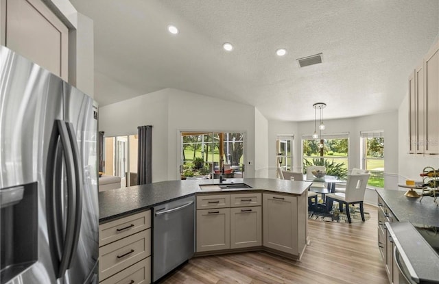 kitchen with stainless steel appliances, light hardwood / wood-style floors, a textured ceiling, hanging light fixtures, and gray cabinets