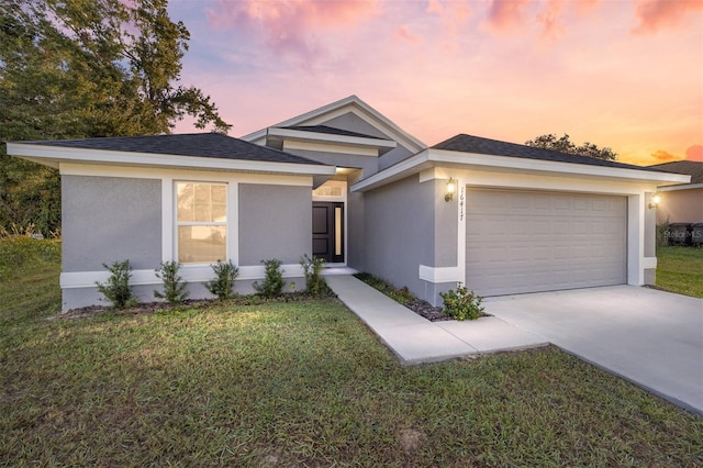 view of front of property featuring a garage and a lawn