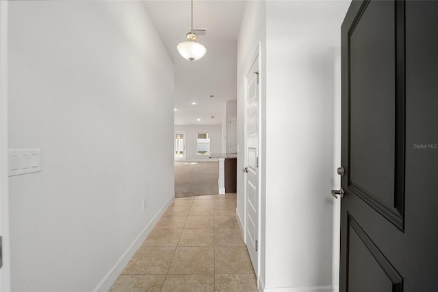 hall with light tile patterned floors