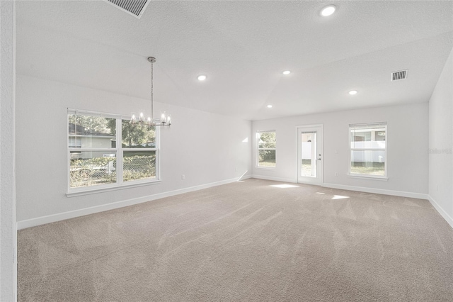 empty room with light carpet, a notable chandelier, a textured ceiling, and vaulted ceiling