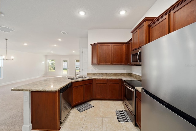 kitchen featuring light stone countertops, light tile patterned flooring, appliances with stainless steel finishes, sink, and decorative light fixtures