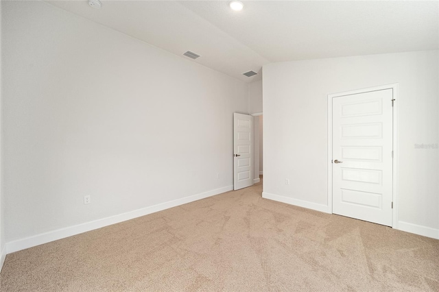 carpeted empty room featuring lofted ceiling