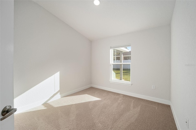 unfurnished room featuring lofted ceiling and carpet floors