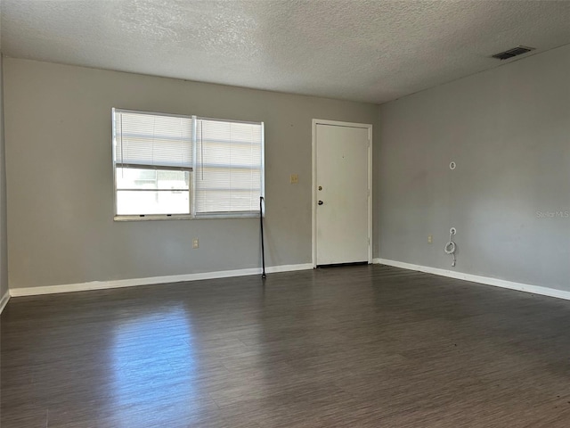 unfurnished room with dark wood-type flooring and a textured ceiling