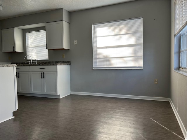 kitchen with white cabinets, a textured ceiling, sink, and dark hardwood / wood-style flooring