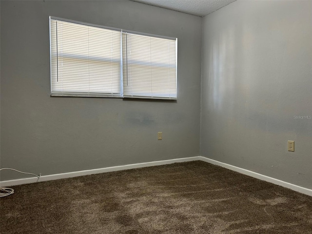 carpeted empty room featuring a textured ceiling