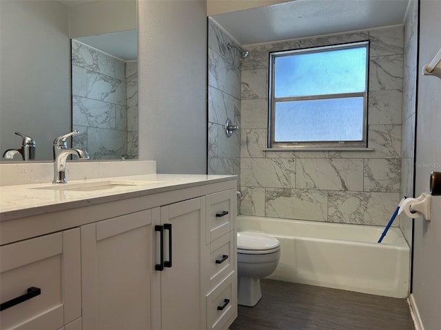 full bathroom with vanity, toilet, hardwood / wood-style flooring, and tiled shower / bath combo