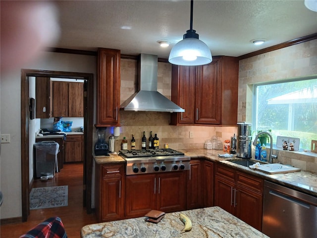 kitchen with light stone counters, wall chimney exhaust hood, pendant lighting, and appliances with stainless steel finishes