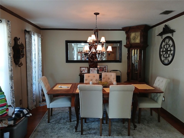 dining space with hardwood / wood-style flooring, ornamental molding, and a chandelier